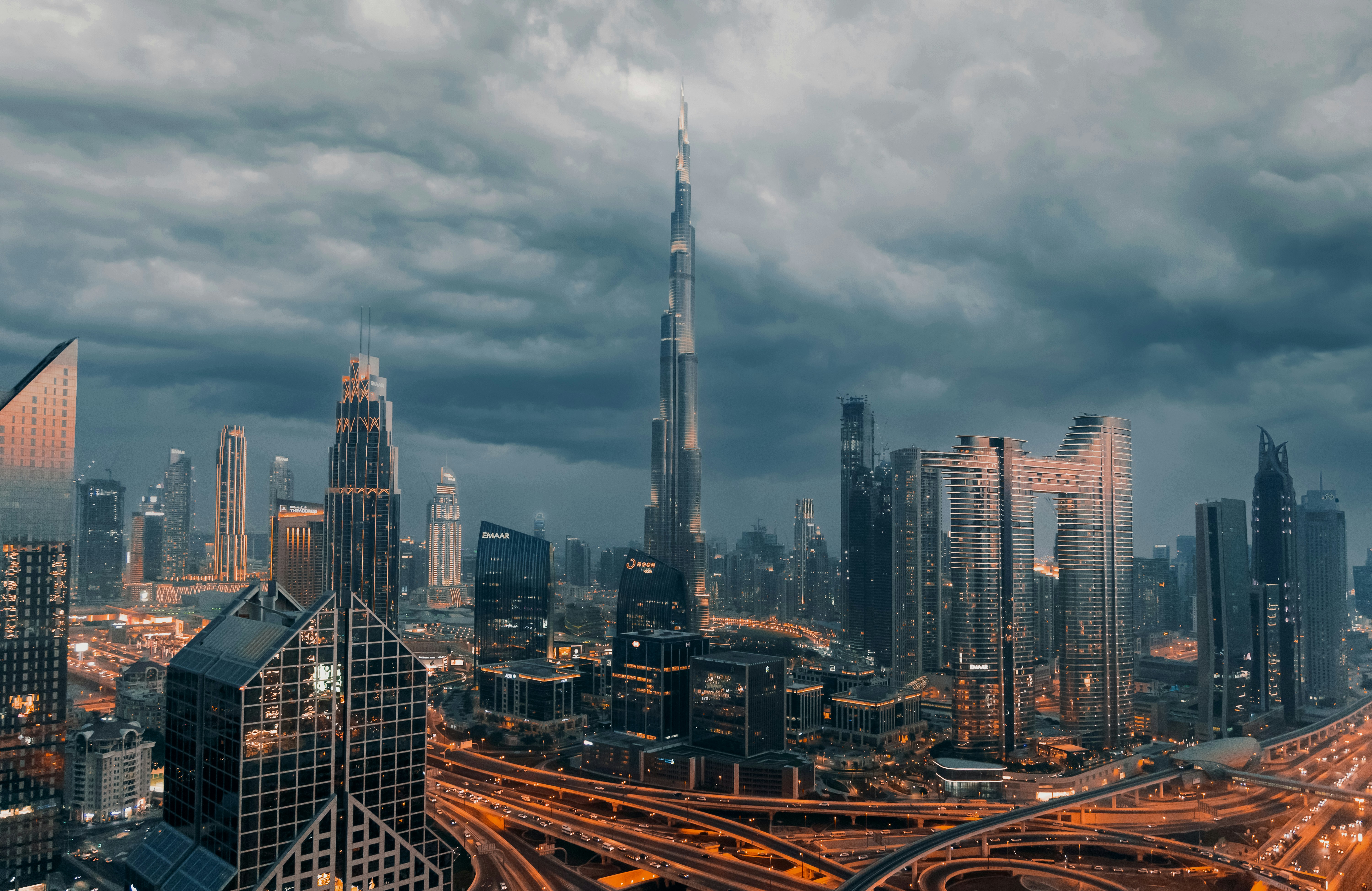 Dubai skyline with the Burj Khalifa under dark storm clouds at dusk