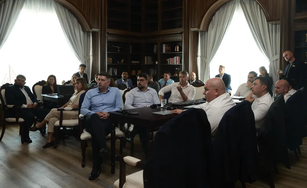Professionals listening to a discussion in a wood-panelled meeting room