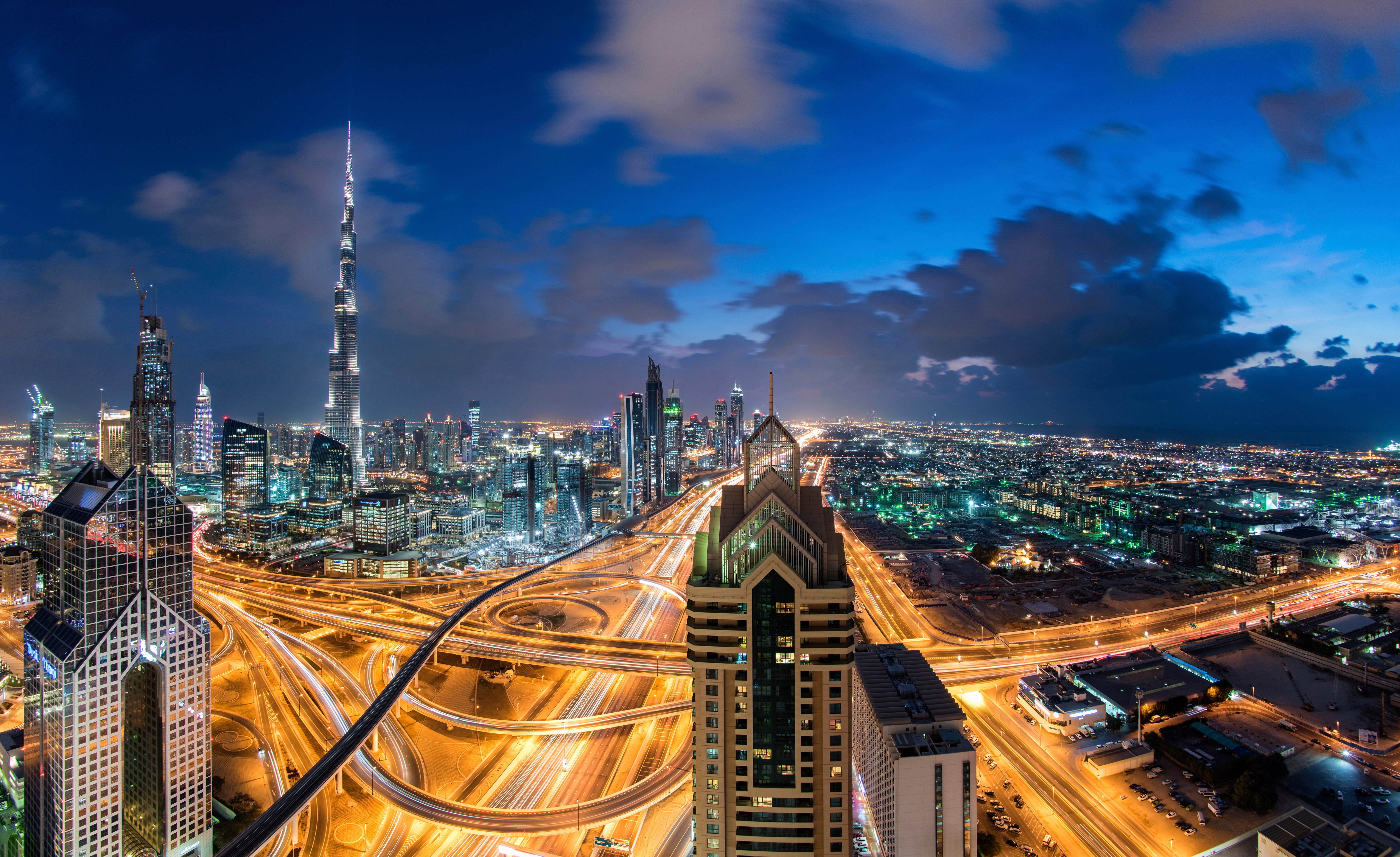 Dubai skyline at dusk with the Burj Khalifa and light trails on busy interchanges